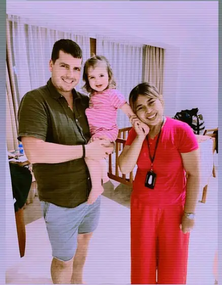 A nanny and a dad with a smiling toddler