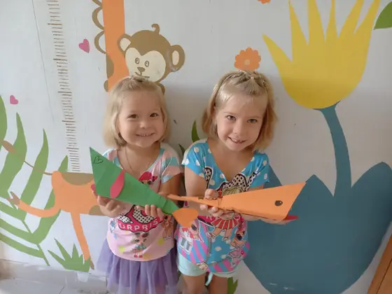 Two little girls posing by a painted wall