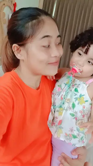A nanny cuddling a toddler