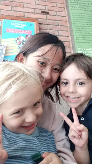 A nanny taking a selfie with two happy children