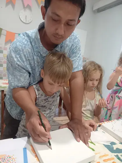 A team member helping children with drawing