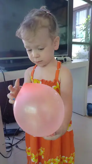 A little girl holding a big balloon