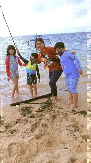 A nanny and children playing on the beach