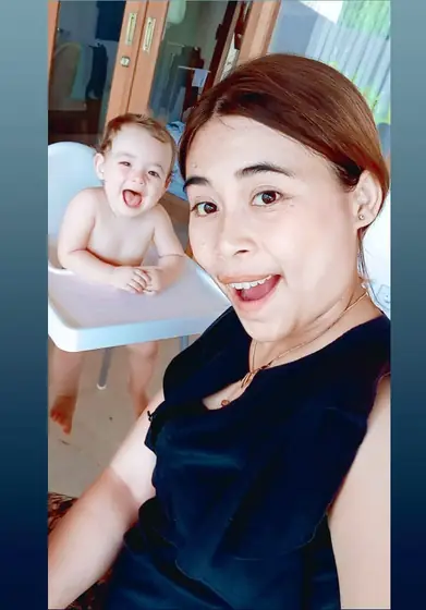 A nanny taking a selfie with a baby