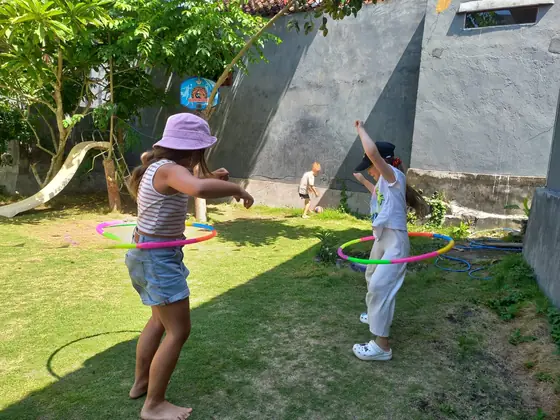 Children playing with hula hoops on the lawn