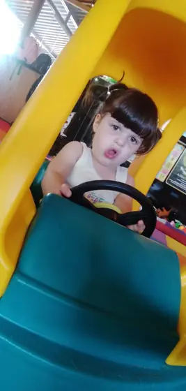 A toddler in a toy car