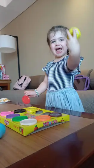A little girl laughing and playing with play dough