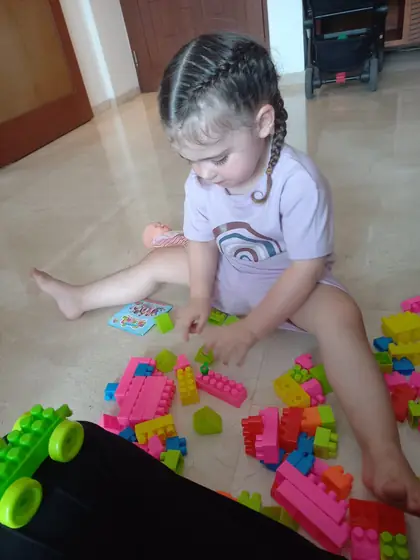 A toddler playing with building blocks